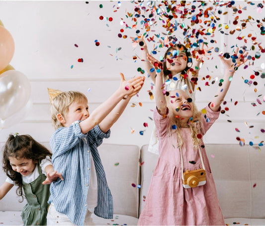 Children throw confetti in the air